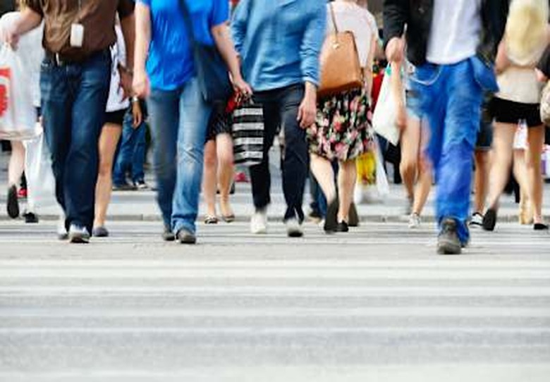 Motion blurred pedestrians crossing sunlit street