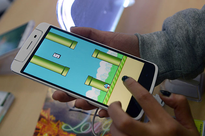 An employee plays the game Flappy Bird at a smartphone store in Hanoi on February 10, 2014. The Vietnamese developer behind the smash-hit free game Flappy Bird has pulled his creation from online stores after announcing that its runaway success had ruined his 
