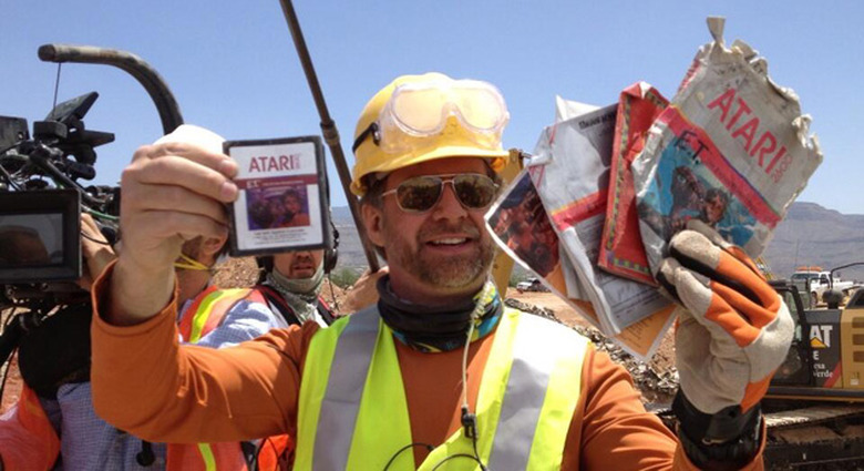 Excavators hold up E.T. for the Atari 2600
