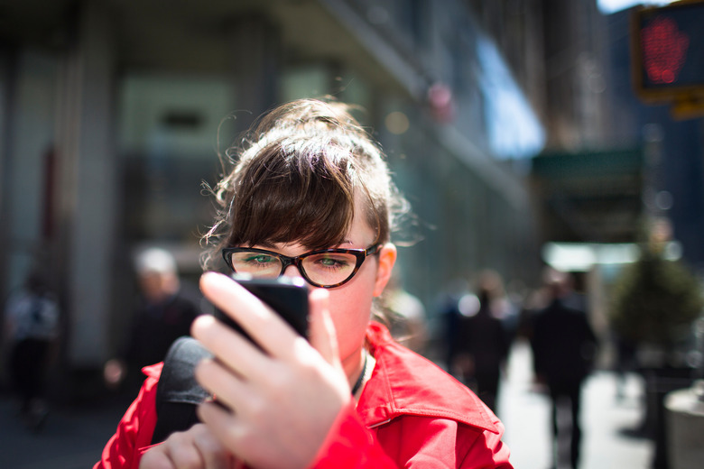 Woman on city street looking at smartphone