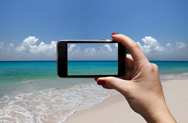 woman photographing a beach with i-phone