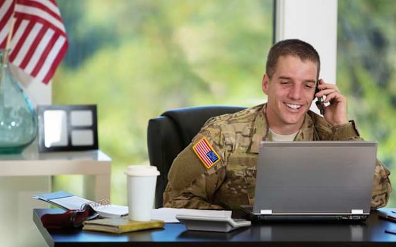 Handsome American soldier behind his computer -talking on the phone