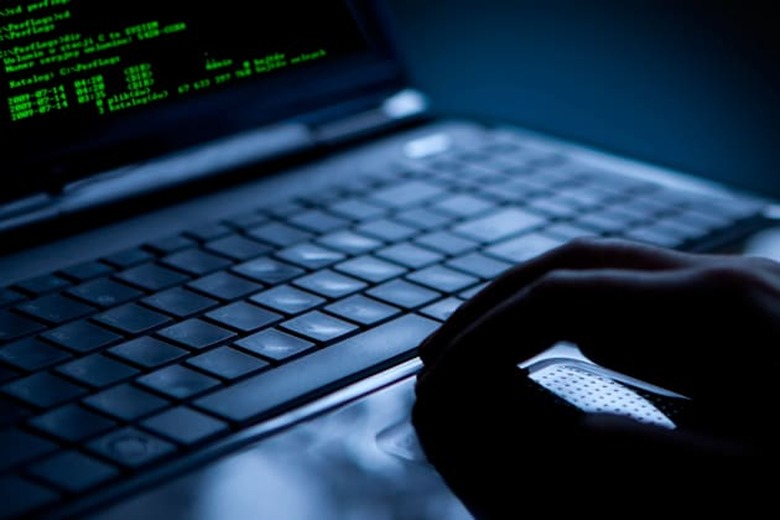 CE53N2 Hacker using laptop. Lots of digits on the computer screen. Stealing; Thief; Identity; Laptop; Hacker; Computer; Securit