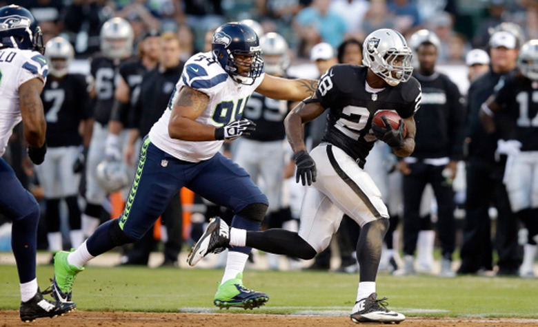 Seahawks try to stop the Raiders' ball carrier