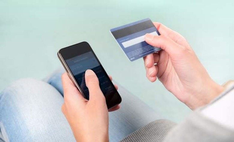 D0G6PE Woman verifies account balance on smartphone with mobile banking application. mobile banking phone Mobile; Phone; Bankin