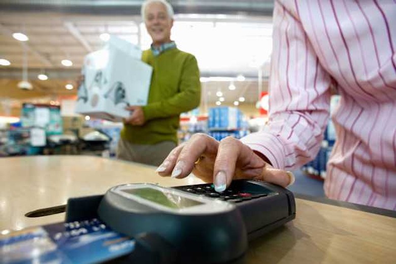 B0BKYT Woman paying with chip and pin by man with boxes, low angle view woman; paying; chip; pin; man; box; close; up; color; im