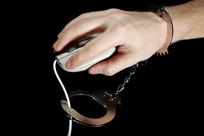 Arrested hacker holding computer mouse
