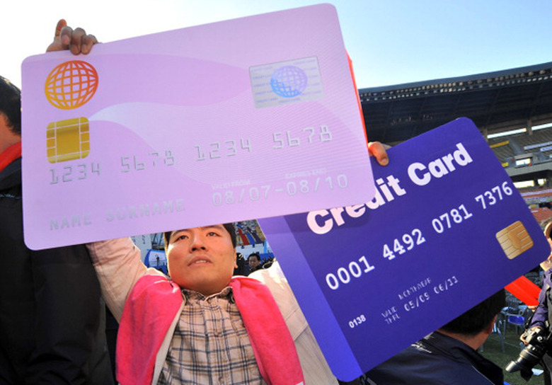 South Korean protester holds up mock credit cards