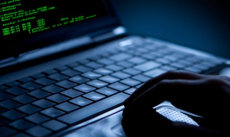 Hacker using laptop. Lots of digits on the computer screen.