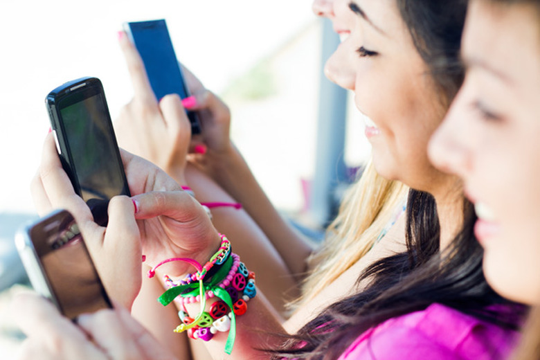 Girls tapping away on smartphones