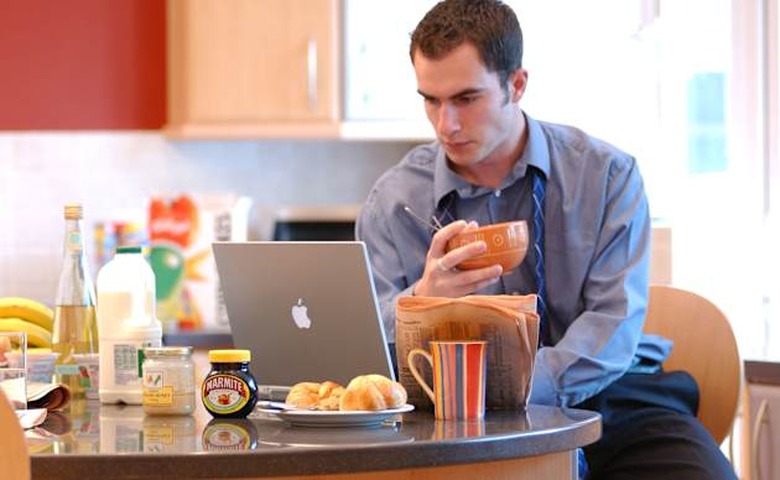 A6K0KP British business man checking emails at home London UK working from home laptop kitchen counter adult male serious