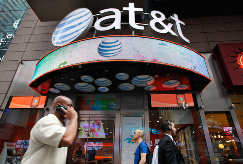 People walk by an AT&T store