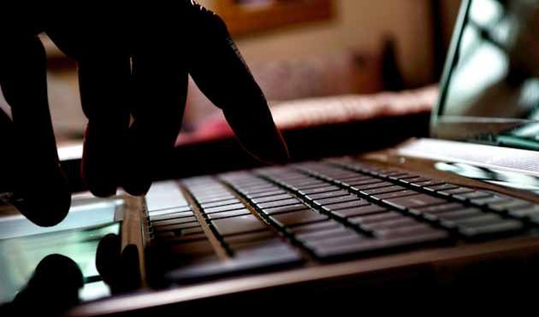 cyber crime hacker typing on laptop