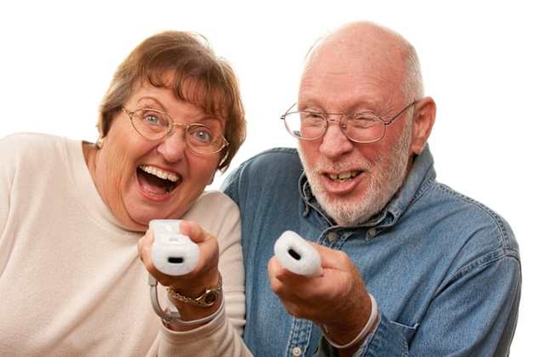 Happy Senior Couple Play Video Game with Remotes