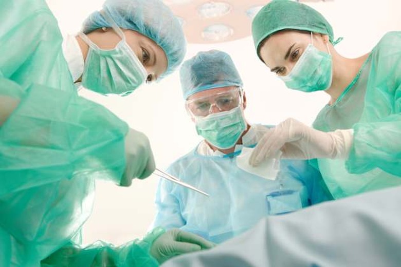 Surgeons and medical assistant wearing mask and uniform operating patient.?