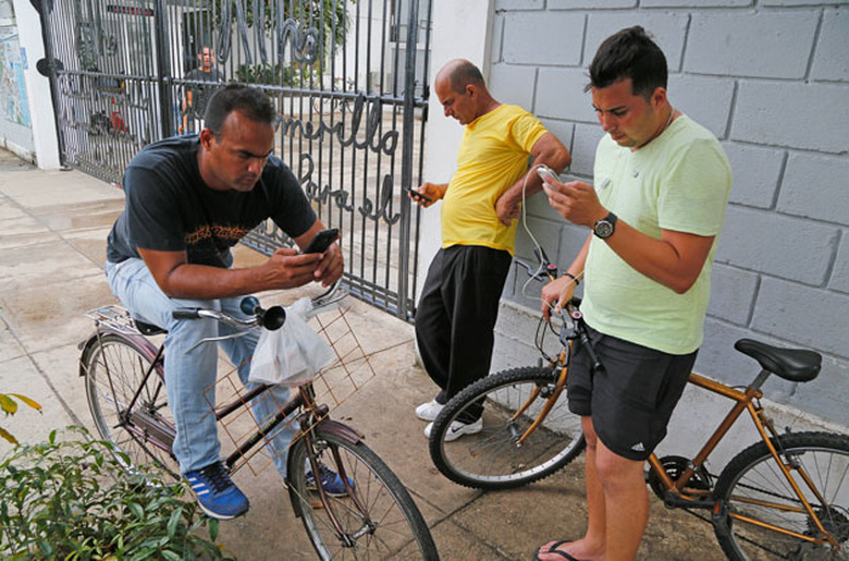 Cubans use the lone free legal WiFi access point in Havana