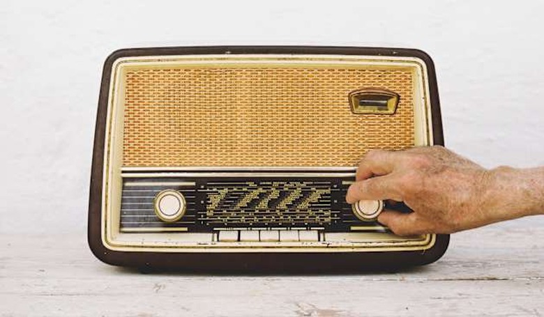 Man's hands on old radio