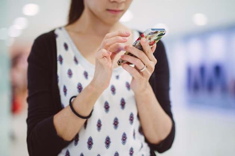 Young lady using smartphone in mall