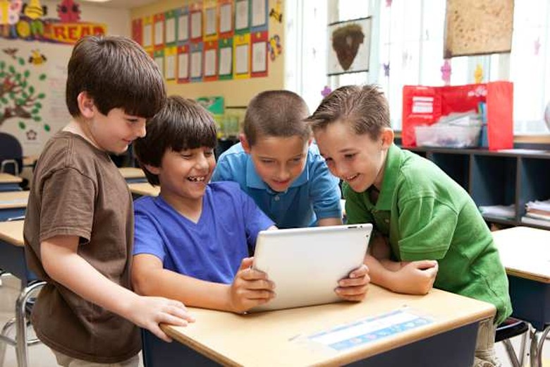 Kids looking at ipad / tablet in classroom