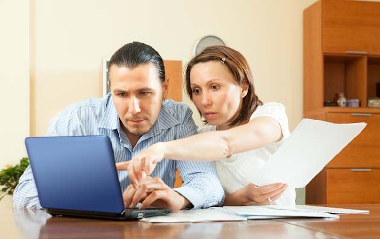 wistful couple calculating budget at home interior