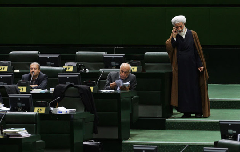 A cleric uses his smartphone in the Iranian parliament