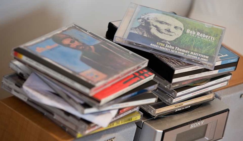 C3AM7C Music CDs piled on top of small Sony music centre in living room of family home music; cds; compact; disc; discs; disk;