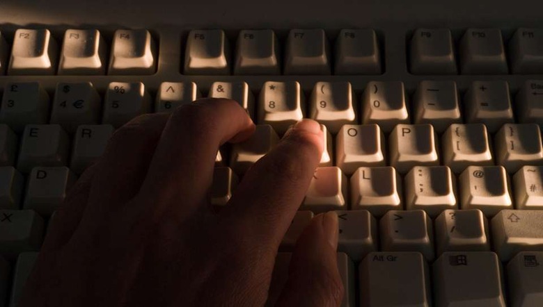 A42KRR Hand on computer keyboard, identity fraud concept. Image shot 2007. Exact date unknown.
