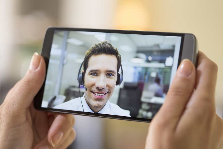 Closeup of a female hand holding a smart phone during a skype video