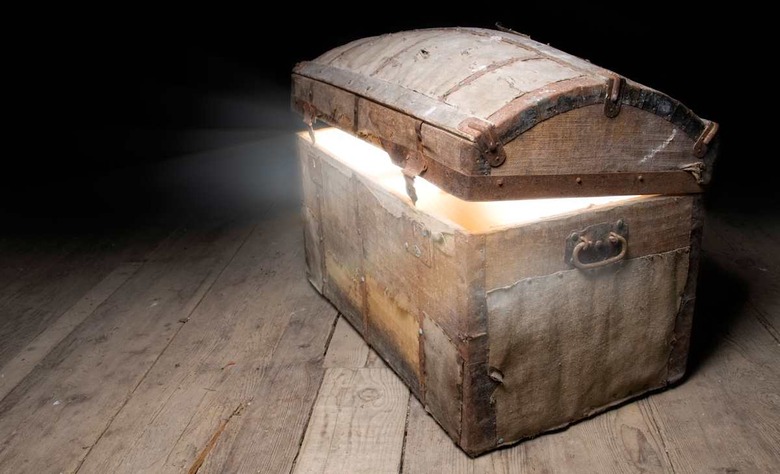 BR7M5R Old wooden treasure chest with strong glow from inside. box; tomb; vintage; Pandora; treasure; shrine; chest; gem; full;