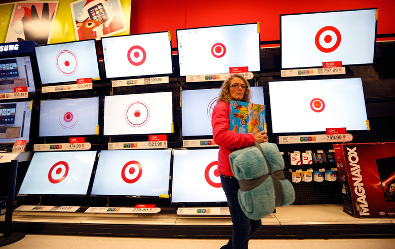 A Target shopper walks by TVs