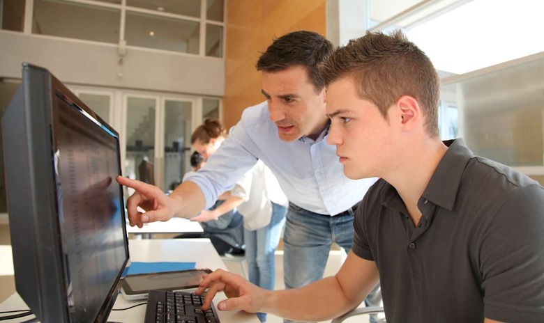 Teacher and student working on computer
