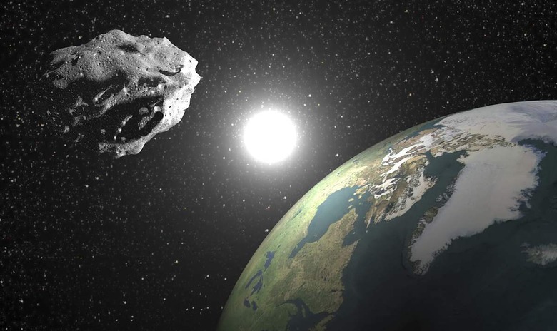 One asteroid into universe near earth planet, sun in the background - Elements of this image furnished by NASA