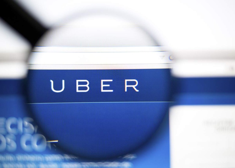 LISBON, PORTUGAL - June 6, 2015: Photo of: www.uber.com, uber homepage on a monitor screen through a magnifying glass.