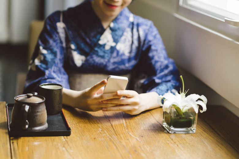 Girl using phone at a table 
