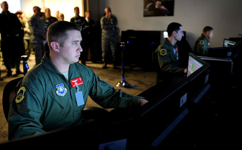 Staff Sgt. Jason Wassom, 3rd Space Operations Squadron, sits at a student station in the new Space Trainer Integrated Training Center following the ribbon cutting and official opening of the new system. (U.S. Air Force photo/Dennis Rogers)