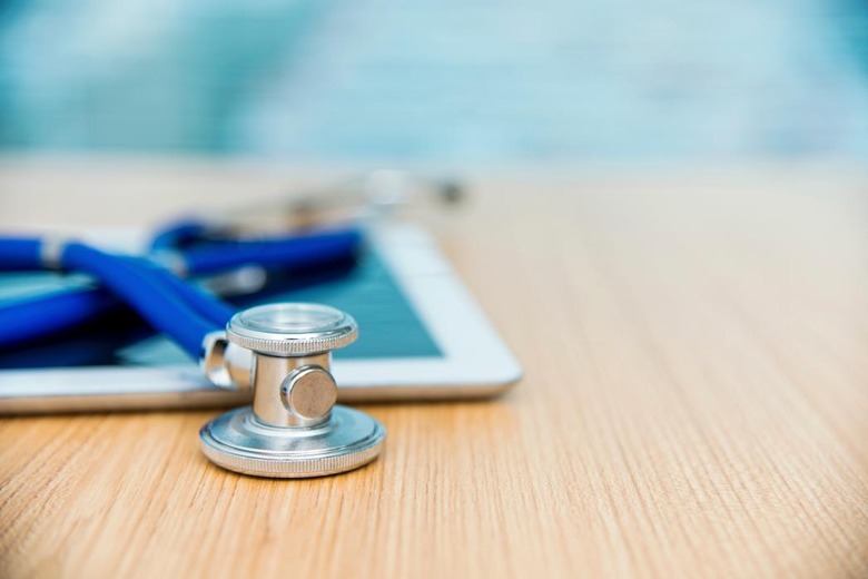 Digital tablet and stethoscope on desk of doctor office.