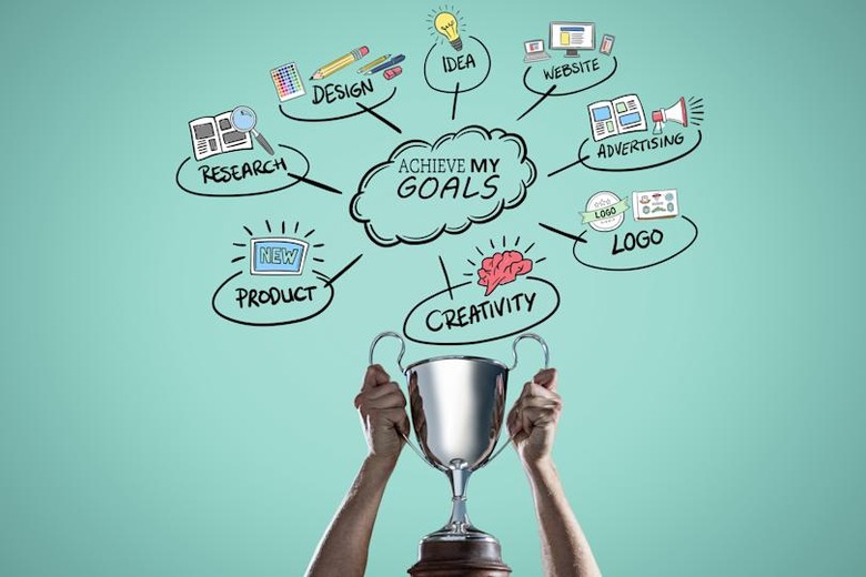 composite of Hands holding cup with goals graphics