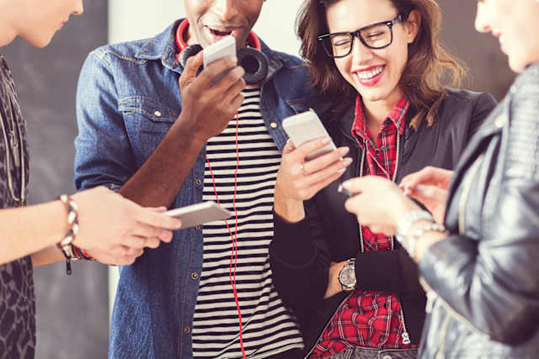 Friends using smart phones, close up of hands