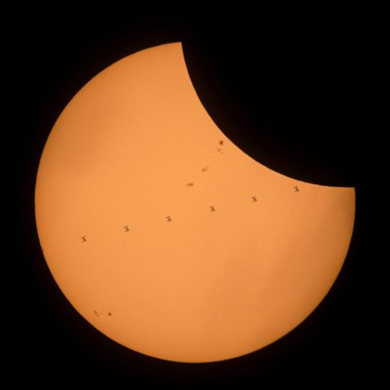This composite image, made from seven frames, shows the International Space Station, with a crew of six onboard, as it transits the Sun at roughly five miles per second during a partial solar eclipse, Monday, Aug. 21, 2017 near Banner, Wyoming. Onboard as part of Expedition 52 are: NASA astronauts Peggy Whitson, Jack Fischer, and Randy Bresnik; Russian cosmonauts Fyodor Yurchikhin and Sergey Ryazanskiy; and ESA (European Space Agency) astronaut Paolo Nespoli. A total solar eclipse swept across a narrow portion of the contiguous United States from Lincoln Beach, Oregon to Charleston, South Carolina. A partial solar eclipse was visible across the entire North American continent along with parts of South America, Africa, and Europe. Photo Credit: (NASA/Joel Kowsky)