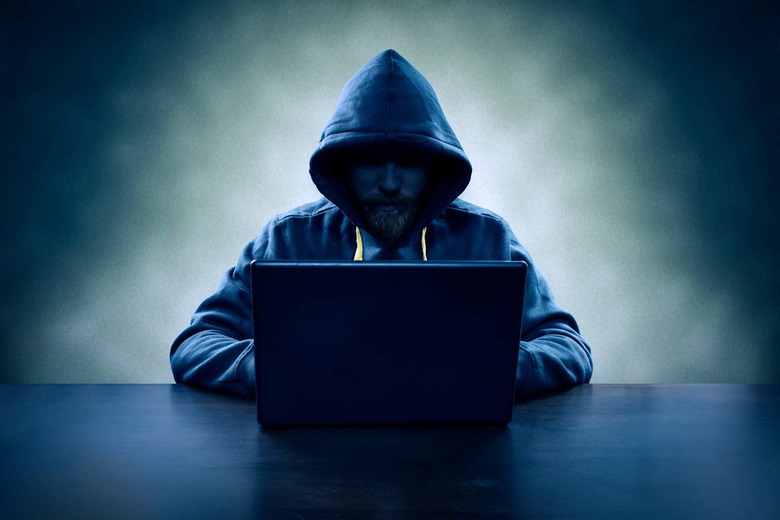 Computer hacker stealing information with laptop