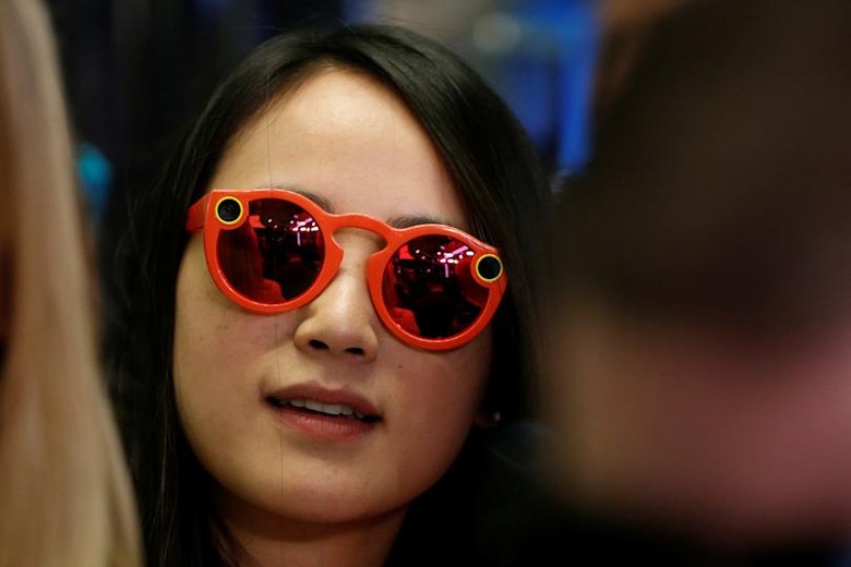 A woman wears Snapchat Spectacles on the floor of the New York Stock Exchange (NYSE) while waiting for Snap Inc. to list their IPO in New York, U.S., March 2, 2017. REUTERS/Lucas Jackson