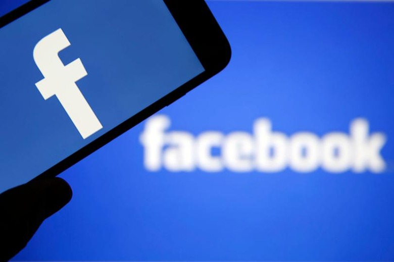PARIS, FRANCE - MARCH 20: In this photo illustration the Facebook logo is seen on the screen of an iPhone in front of a computer screen showing a Facebook logo on March 20, 2018 in Paris, France. Cambridge Analytica is accused of collecting the personal information of 50 million users of the Facebook social network without their consent and would have used it to develop software to predict and influence voter voting during the campaign American election according to the New York Times and the Guardian. Facebook share price fell by more than 5% Monday shortly after the opening of Wall Street. (Photo Illustration by Chesnot/Getty Images)