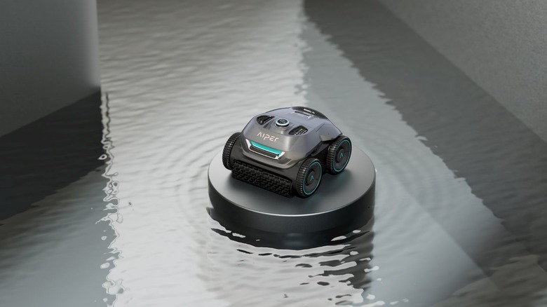 Product photography of the Aiper Seagull Pro pool-cleaning robot sitting on a floating platform in a swimming pool