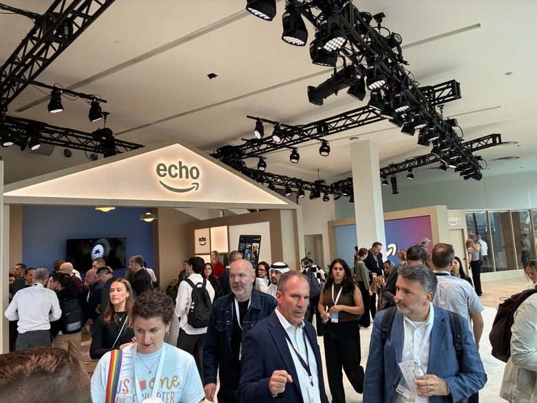A bright room with lots of people and Amazon Echo branding on a structure.