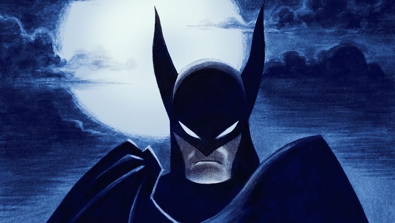 Promotional artwork for the series ‘Batman: Caped Crusader,’ featuring Batman scowling in a dark and moody nighttime scene with the moon behind him.