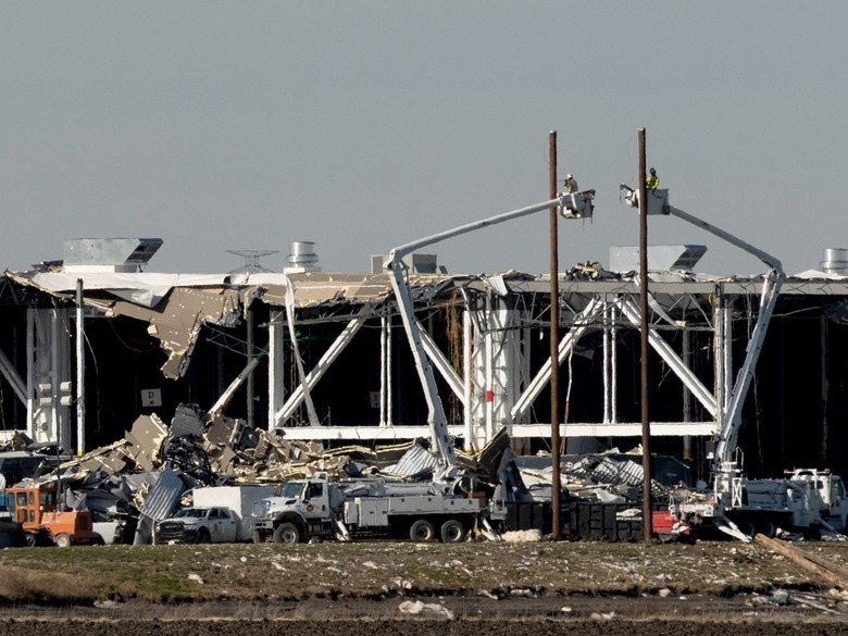 Amazon crew on lifts document the damage from the tornado that hit an Amazon distribution centre where the roof collapsed in Edwardsville, Illinois, U.S. December 13, 2021.  REUTERS/Lawrence Bryant