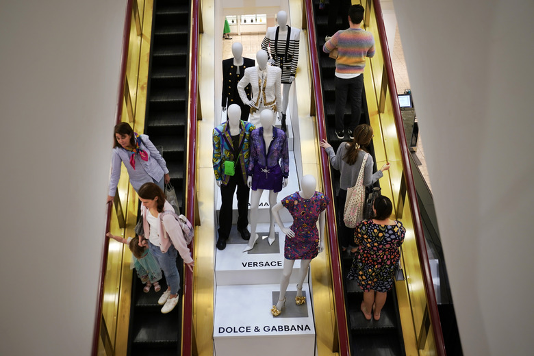 FILE - Shoppers move past displays of designer clothes at the Neiman Marcus department store in NorthPark shopping center in Dallas, March 30, 2023.The parent company of Saks Fifth Avenue has signed a deal to buy upscale rival Neiman Marcus Group, which owns Neiman Marcus and Bergdorf Goodman stores, in a deal announced on Thursday, July 4, 2024. (AP Photo/LM Otero, File)