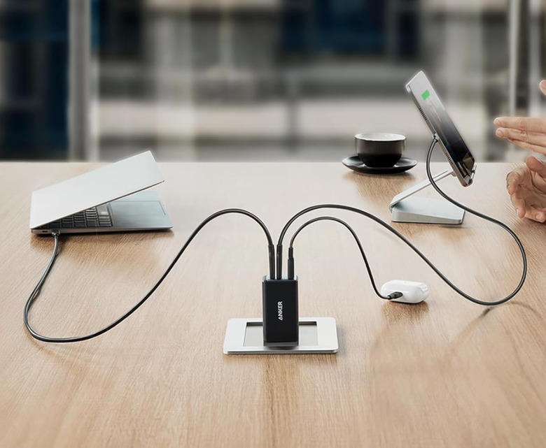 A charger on a table connected to multiple devices. 