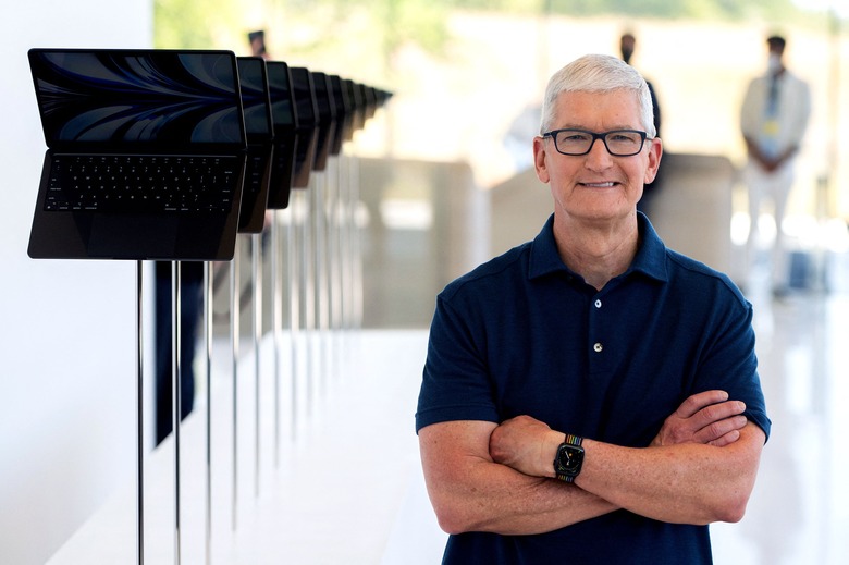 Apple CEO Tim Cook poses for a portrait next to a line of new MacBook Airs as he enters the Steve Jobs Theater during the Apple Worldwide Developers Conference (WWDC) at the Apple Park campus in Cupertino, California on June 6, 2022 . (Photo by Chris Tuite / AFP) (Photo by CHRIS TUITE/AFP via Getty Images)