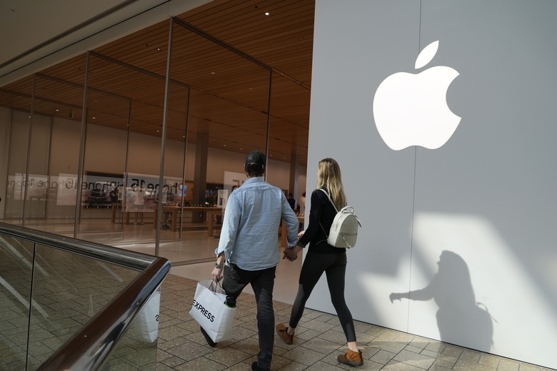 People walk by an Apple store Oct. 20, 2023, in Denver. Apple is now requiring that U.S. law enforcement agencies obtain a court order for information on its customers' push notifications â the alerts iPhone apps send users that can reveal a lot about their online activity. (AP Photo/Brittany Peterson, File)